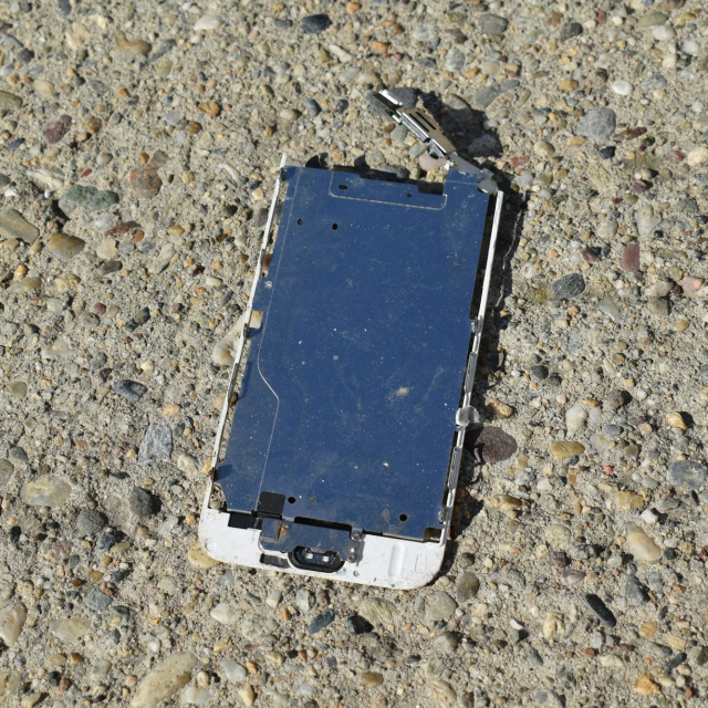 A broken cell phone laying on the ground