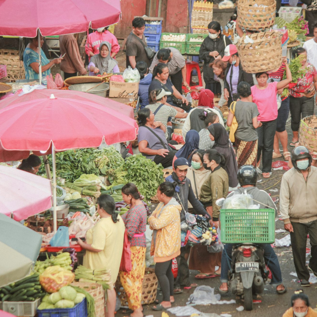 A large group of people walking around a market