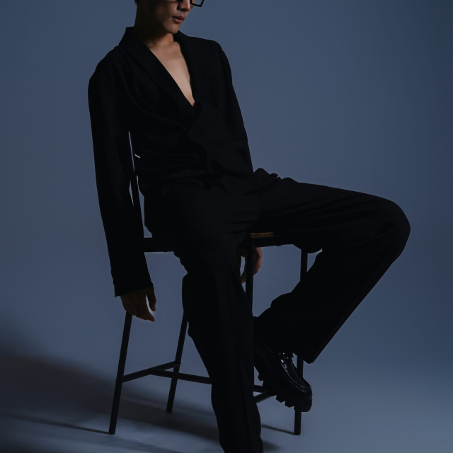 A man sitting in a chair with his legs crossed