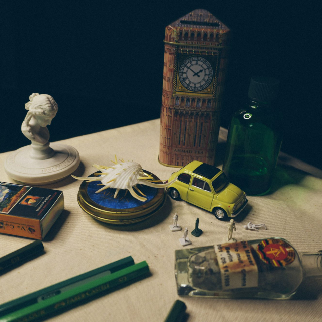 A table topped with a bottle of liquor and a clock tower