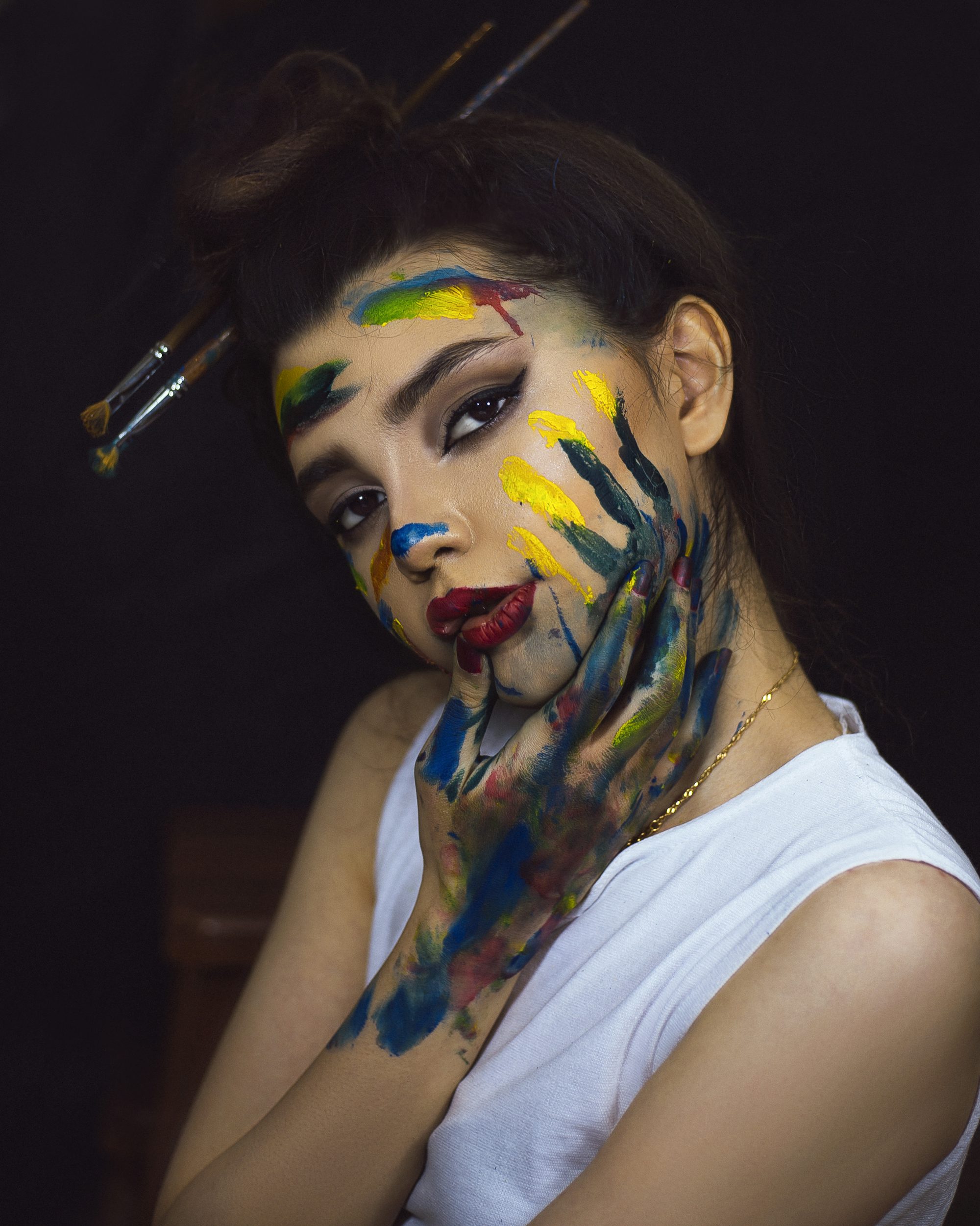 Woman in white tank top with red and black face paint